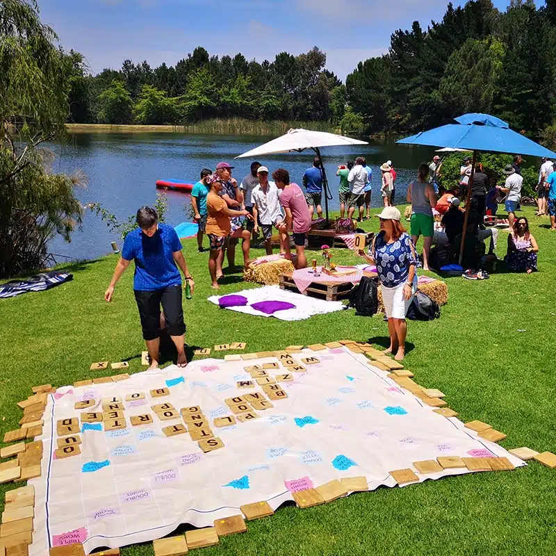 Colleagues playing giant Scrabble on the lawn at a Lawn Games and Lunch year-end function Colleagues playing giant Scrabble on the lawn at a Lawn Games and Lunch year-end function
